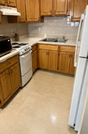 Same kitchen after cleaning with clear counters and a clean floor