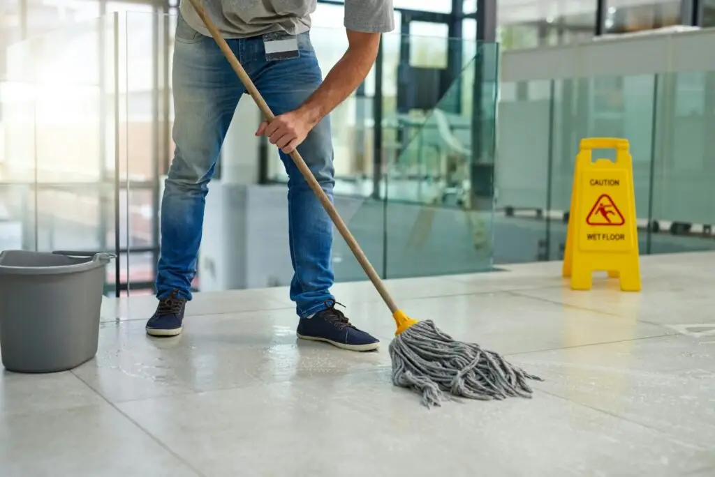 Hell leave that floor spotless. Shot of an unrecognizable man mopping the office floor.